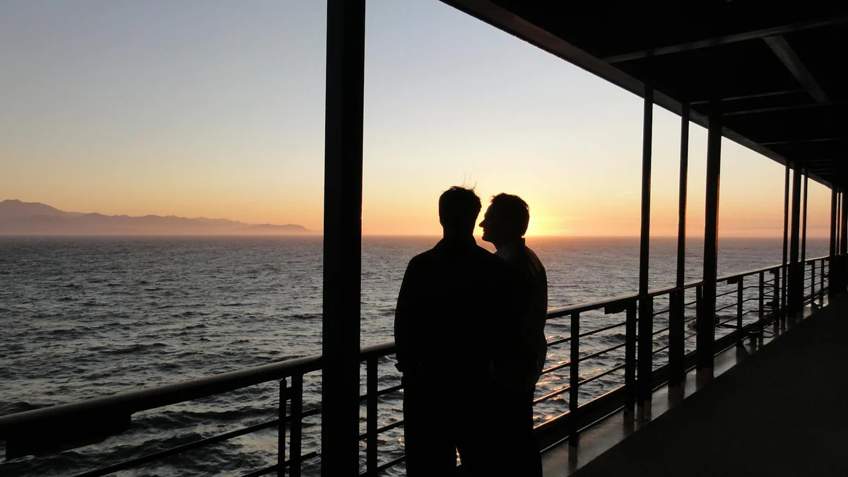 Pareja en la cubierta de un crucero disfrutando de su primer viaje en barco